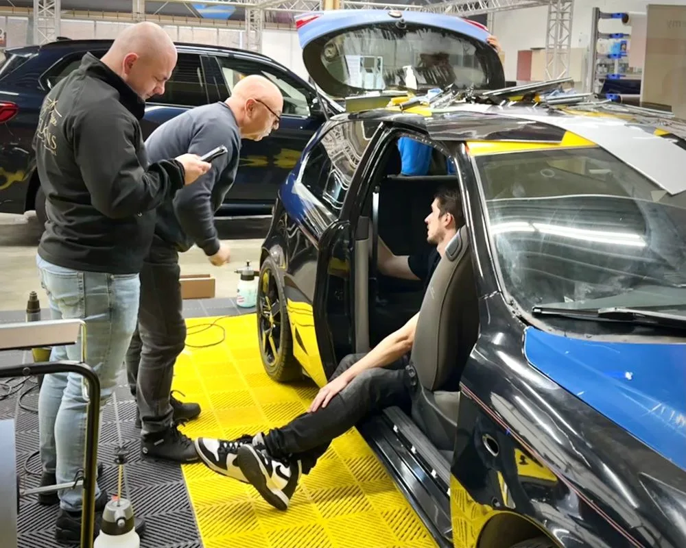 Cursisten in en bij demoauto in gesprek over raamfolies tijdens Appcademy Automotive Windowfilm training