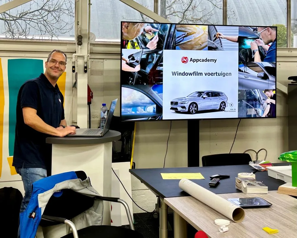 Trainer geeft info over raamfolie bij power point presentatie tijdens Appcademy Automotive Windowfilm opleiding