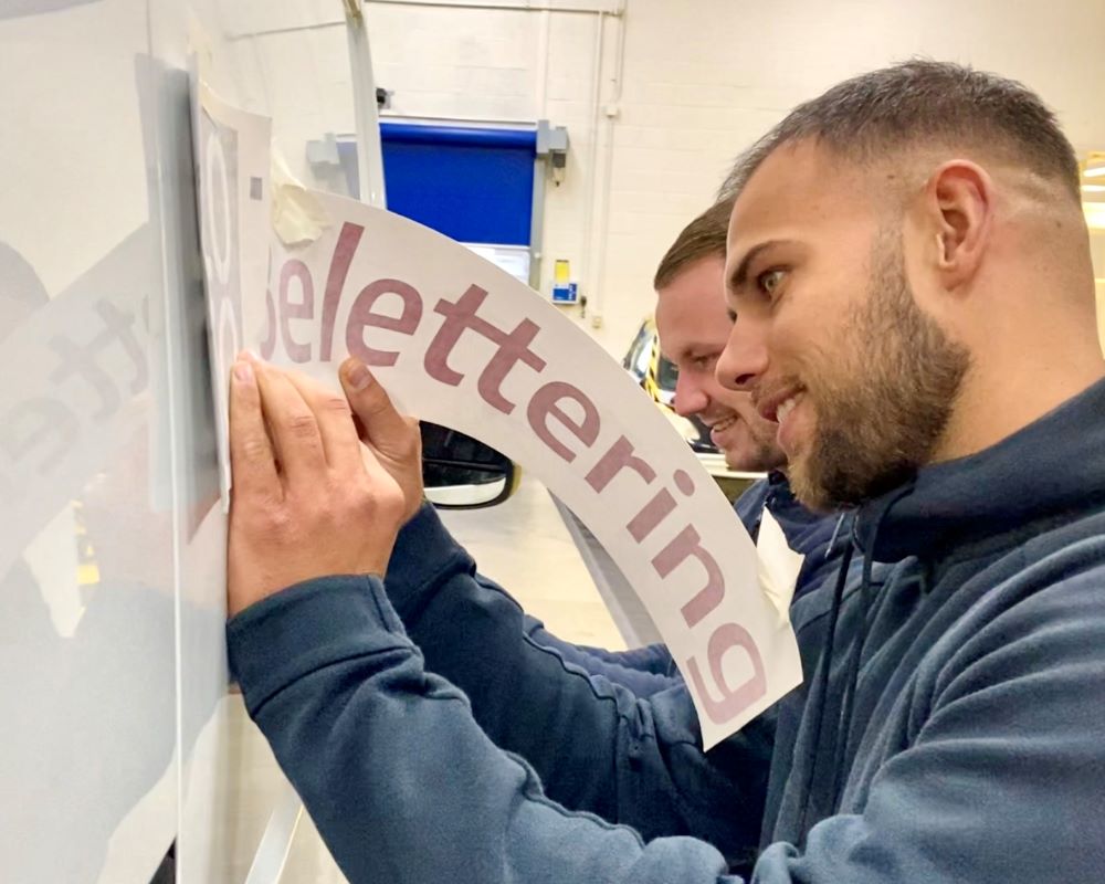 Cursisten leren in de praktijk zelf belettering plakken tijdens de Appcademy signmaker training