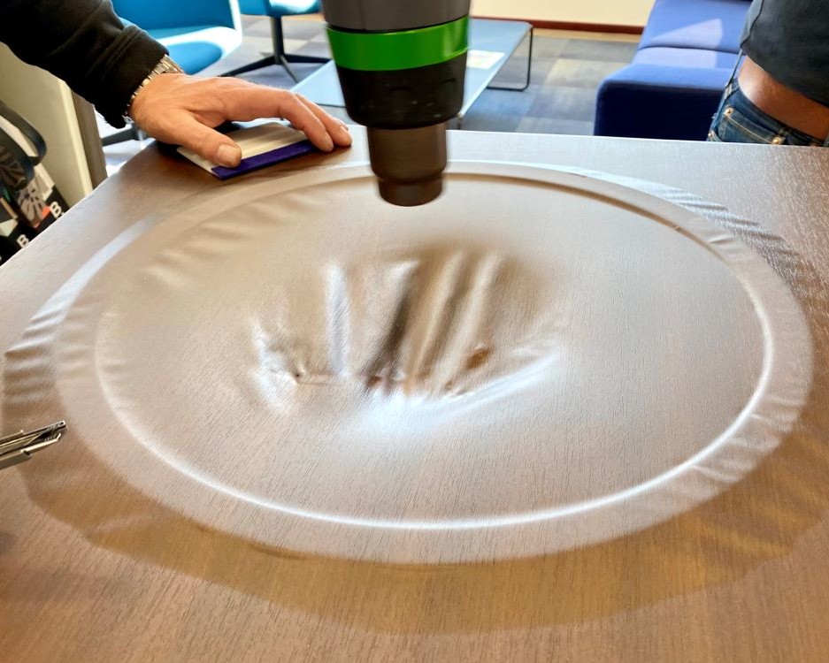 Trainer demonstreert de rekbaarheid van interieurfolie tijdens Appcademy opleiding interieurfolie plakken en keukens wrappen