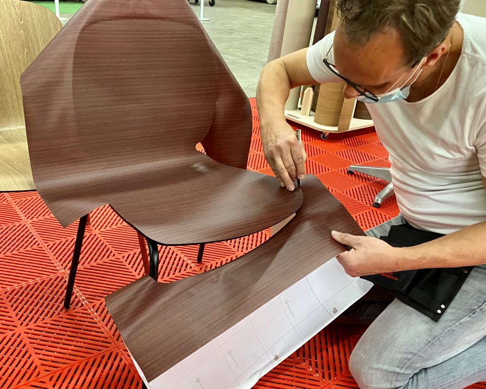 Cursist doet praktijkoefening stoel wrappen tijdens de Appcademy cursus interieurfolie en keukens wrappen