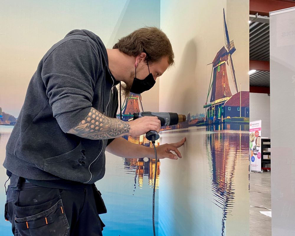 Cursist gebruikt föhn of heatgun bij aanbrengen naadloos fotobehang tijdens deelname Appcademy Naadloos fotobehang cursus