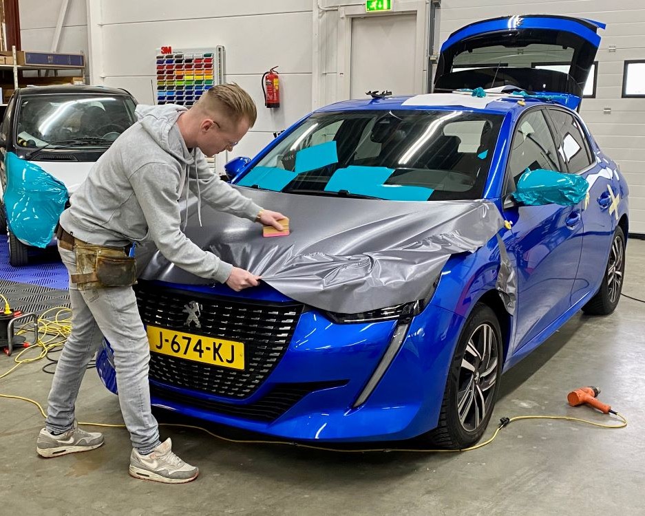 Trainer demonstreert het wrappen van motorkap tijdens Appcademy carwrap training